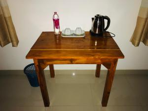a wooden table with a coffee pot and shoes on it at River Cottage Safari in Udawalawe