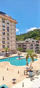 un grand hôtel avec une piscine et un bâtiment dans l'établissement Estudio Em Itaipava - Granja Brasil - Flat Luxo - Com Piscina Aquecida, à Itaipava