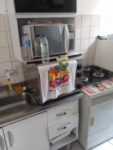 een keuken met een wastafel en een magnetron bij Apto 2px.unesc in Criciúma