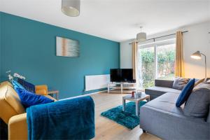 a blue living room with a couch and a tv at CONTRACTORS, Central MK, Free off street Parking, close to amenities, Managed by Chique Properties Ltd in Milton Keynes