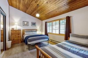 a bedroom with two beds and a wooden ceiling at Bay Point Hillside 17A Up in Whitefish +18 photos