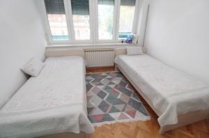 twee bedden in een kamer met een raam bij Latin Apartment in Sarajevo