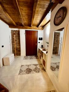 un couloir avec un plafond en bois et une horloge sur le mur dans l'établissement Loft La Lanterna, à Gênes