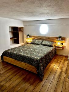 a bedroom with a large bed with a wooden floor at Loft La Lanterna in Genova