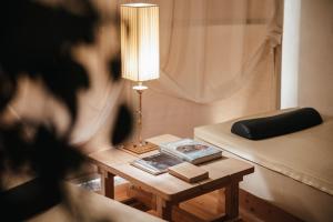 a lamp on a table next to a bed at Residence Villa Trieste in Corvara in Badia