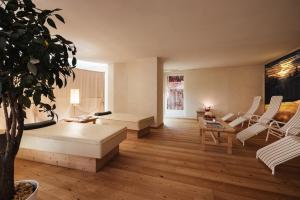 sala de estar con sofá, mesa y sillas en Residence Villa Trieste, en Corvara in Badia
