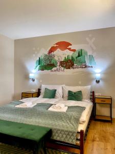 a bedroom with a large bed with a painting on the wall at Vila Diana in Ždiar