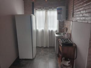 a kitchen with a white refrigerator and a window at La Posada De Vito in Córdoba