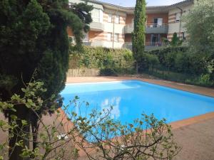 a large blue swimming pool in front of a building at Résidence avec Parking et piscine - Proche airport in Blagnac