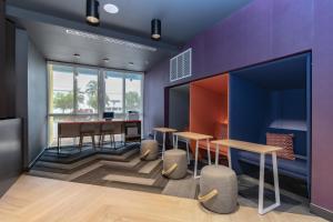 佛羅里達市的住宿－Tru By Hilton Florida City, Fl，紫色墙壁、桌子和凳子的房间