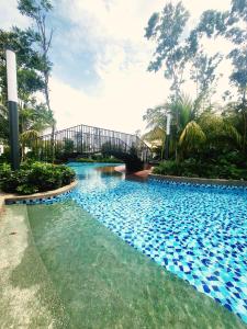ein Schwimmbad mit einer Brücke im Hintergrund in der Unterkunft Gaia Residences, Gamuda Garden, 3 min to Skyline Luge in Rawang