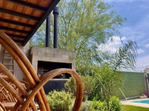 a patio with a fireplace and a tree and a pool at Casa Quinta FP en Rio Cuarto in Río Cuarto