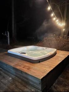 bañera sobre una mesa de madera en Hidden Oasis: Pool, Hot Tubs, & Starry Fire Pits, 