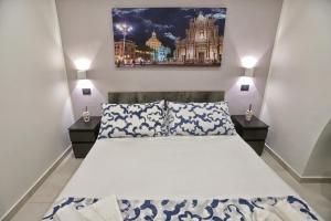 カターニアにあるVicolo 4 Apartmentの大きなベッドと2つのナイトスタンドを備えた寝室