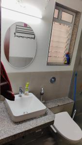 uma casa de banho com um lavatório e um espelho em The TEN 1 em Pune