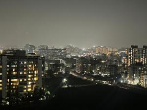 uma vista para uma cidade à noite com luzes em The TEN 1 em Pune