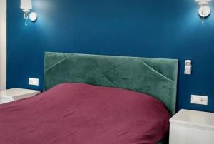 um quarto com uma cama vermelha e uma parede azul em VIP apart 750 em Tbilisi