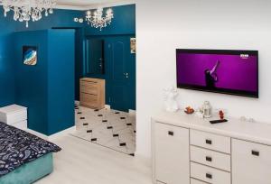 um quarto com paredes azuis e uma televisão na parede em VIP apart 750 em Tbilisi