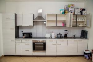 een keuken met witte kasten en een fornuis met oven bij Luxury Home 3bed in Accra