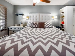ein Schlafzimmer mit einem großen Bett mit einer weißen und grauen Tagesdecke in der Unterkunft Hidden Creek Pond Perfection in Park City