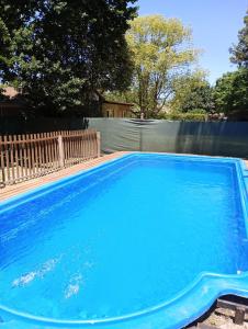 una piscina con agua azul en un patio trasero en Cabañas Los Cardales en Chascomús