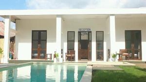uma casa com uma piscina em frente em WHITE SANDS RESORT em Gili Trawangan