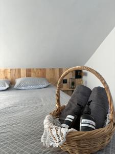 ein Korb mit Weinflaschen auf einem Bett in der Unterkunft Petit Nid Douillet avec parking privé 