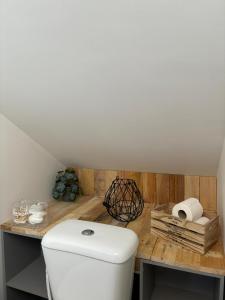 a bathroom with a white toilet and a wooden counter at Petit Nid Douillet avec parking privé 