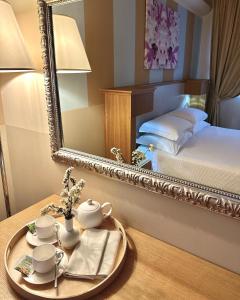 a room with a mirror and a table with a bed at Relais Concorde in Grottammare