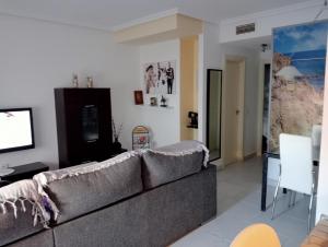 sala de estar con sofá y TV en Apartamento playas de Vera con vistas al mar, en Vera