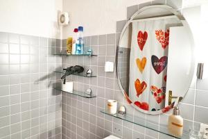 a bathroom with a mirror and a shower curtain at Family room by Interlaken Parking in Därligen
