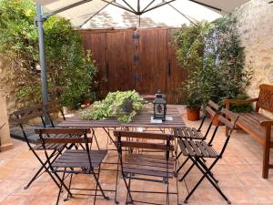 un patio con mesa, sillas y una valla en La casona de Mahora 12 personas, en Mahora