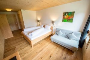 ein kleines Zimmer mit einem Bett und einem Sofa in der Unterkunft Hotel Steinbock Vals in Vals