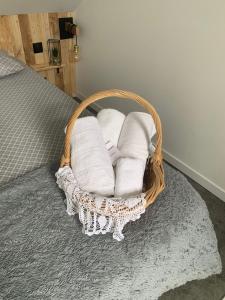 a basket filled with towels on a bed at Petit Nid Douillet avec parking privé 