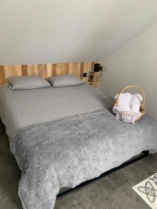 1 dormitorio con 1 cama y una cesta de toallas en Petit Nid Douillet avec parking privé, 