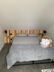 a bedroom with a bed with a basket of towels at Petit Nid Douillet avec parking privé 