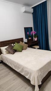a bedroom with a large bed with pillows on it at Апартаменты рядом с метро Раимбек in Almaty