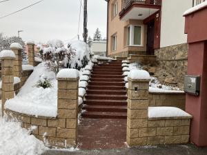 a snow covered stairway to a house with snow at Kosice ubytovanie v rodinnom dome in Košice