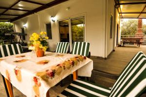 een tafel en stoelen met een tafel en bloemen op een veranda bij Avci Villa-Fethiye 3+1 in Garden with Private Pool, 10 minutes to the beach in Fethiye