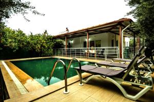 een zwembad met een stoel naast een huis bij Avci Villa-Fethiye 3+1 in Garden with Private Pool, 10 minutes to the beach in Fethiye