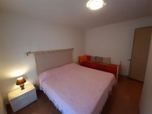 リモーネ・ピエモンテにあるAppartamento Le Colombeの小さなベッドルーム(ベッド2台、ランプ付)