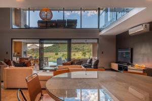 een woonkamer met meubilair en een glazen tafel bij Bakubung Villas in Pilanesberg