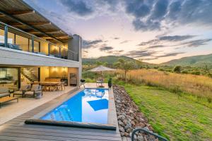 a house with a swimming pool and a patio at Bakubung Villas in Pilanesberg