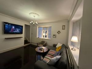 een woonkamer met een bank en een tafel bij Luxury Cottage Room in Londen
