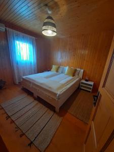 a bedroom with a bed in a wooden room at Pensiunea Valurile Dunarii in Sfântu Gheorghe