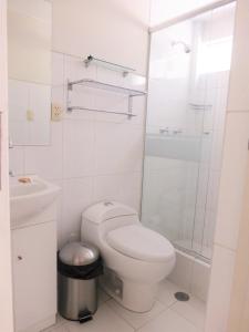 a white bathroom with a toilet and a shower at HOTEL MURCIA AREQUIPA in Arequipa