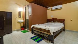 a bedroom with a large bed and a sink at Leo Woods Hampi River view in Hampi