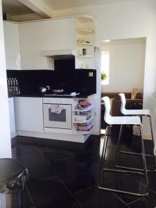 een keuken met een fornuis en 2 witte stoelen bij Luxury Cottage Room in Londen