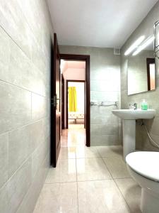 a bathroom with a sink and a toilet and a mirror at Guinea Apartment in Playa del Ingles