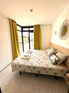 a bedroom with a bed with yellow curtains at Guinea Apartment in Playa del Ingles